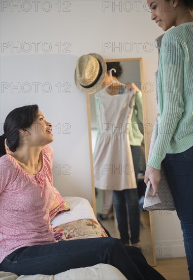 Mother helping daughter choose dress