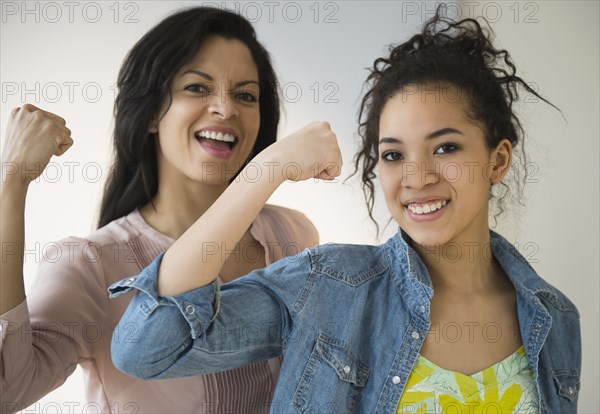 Mother and daughter flexing their muscles