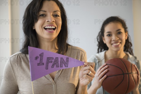 Mother holding fan flag for athlete daughter