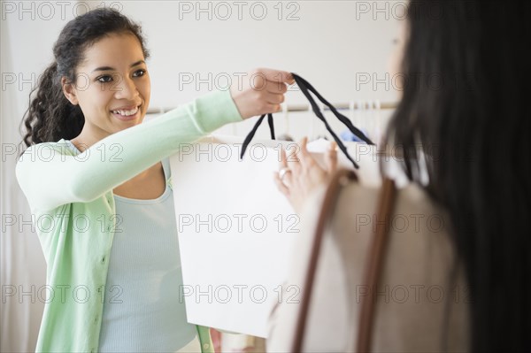Retail worker handing shopping bag to customer