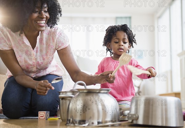 Mother and daughter playing with pots and pans