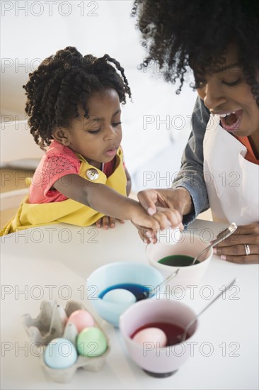 Mother and daughter dyeing Easter eggs