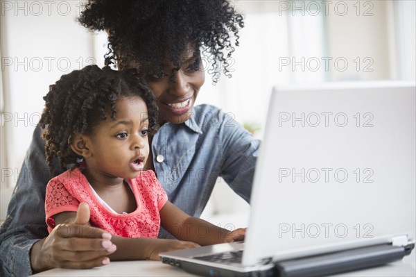 Mother and daughter using laptop