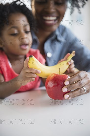 Mother and daughter playing with fruit