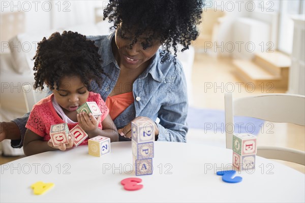 Mother and daughter playing with wooden blocks