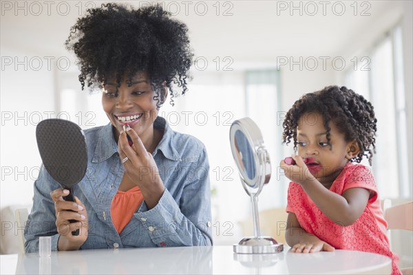 Mother and daughter applying makeup