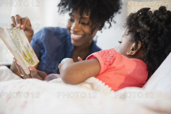 Mother and daughter reading in bed