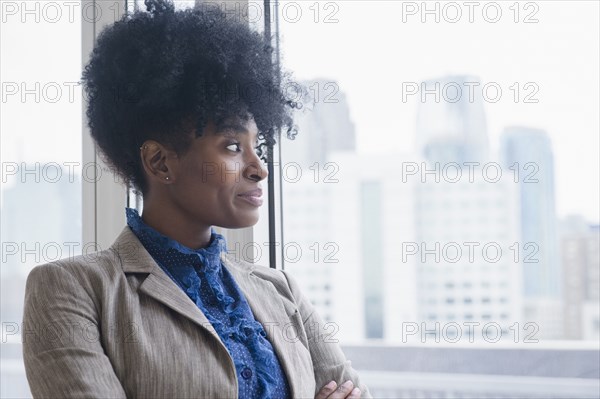 Black businesswoman looking out office window