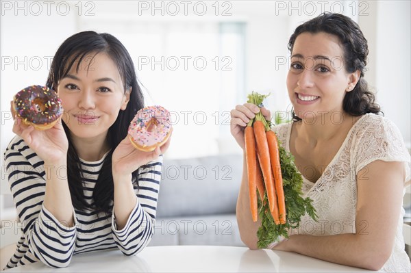 Women choosing between donuts and carrots