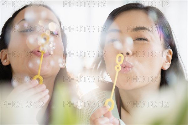 Women blowing bubbles together
