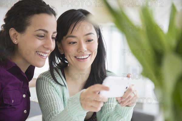 Women using cell phone together