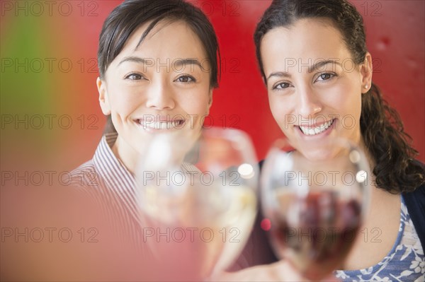 Women toasting each other with wine