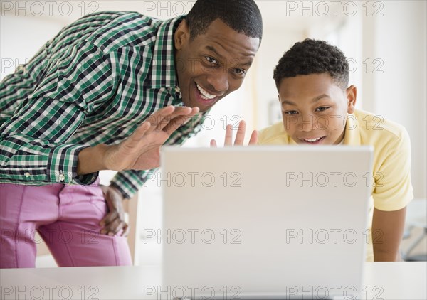 Father and son video chatting on laptop