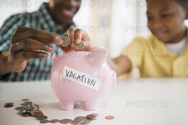 Father and son saving coins for vacation