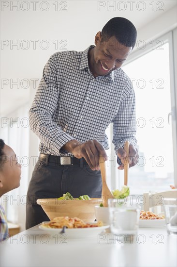 Father and son eating together at table