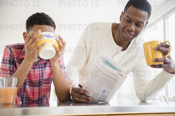 Father and son having breakfast in kitchen