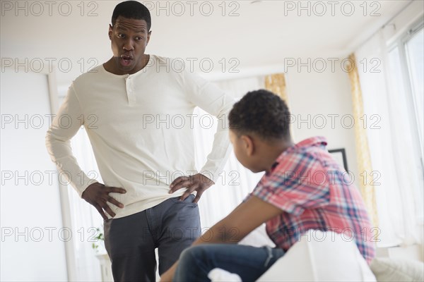 Father scolding son in bedroom