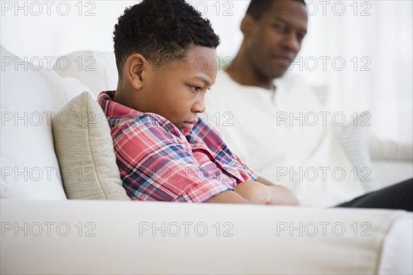 Father and son arguing on sofa