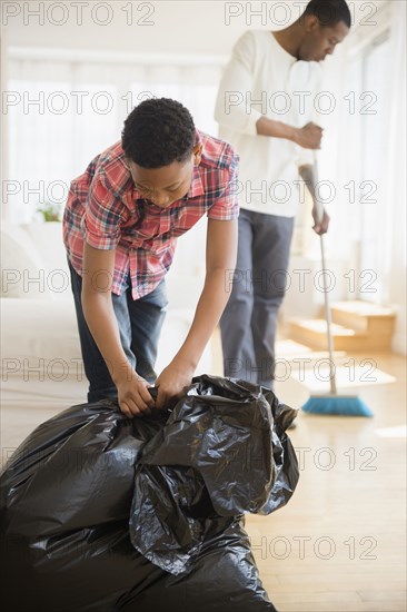 Father and son doing chores in house