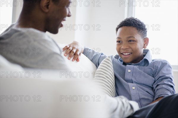 Father and son relaxing on sofa