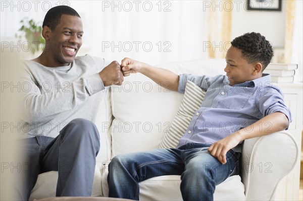 Father and son relaxing on sofa