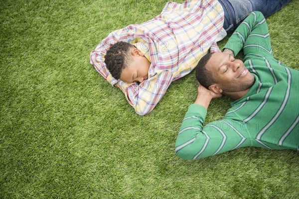 Father and son relaxing in grass