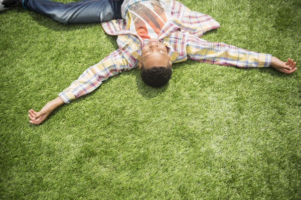 Black boy relaxing in grass