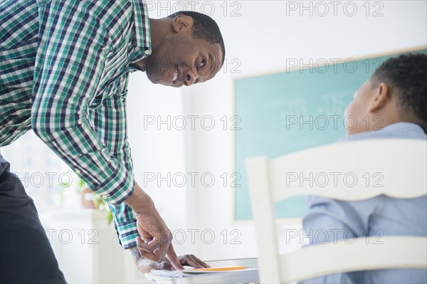 Teacher helping student in classroom