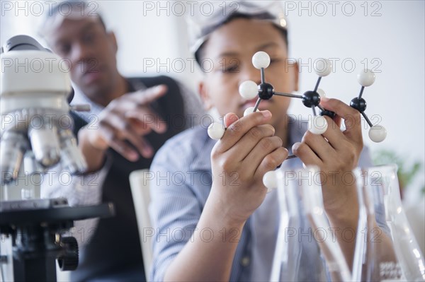 Student examining molecular model in science class