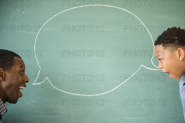 Teacher and student talking by empty speech bubble