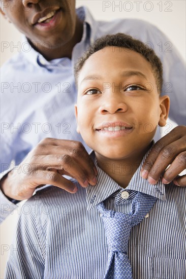 Father adjusting son's tie