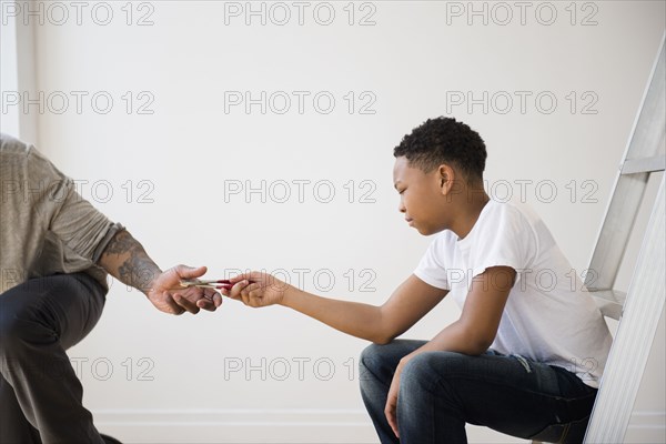 Boy giving father pliers