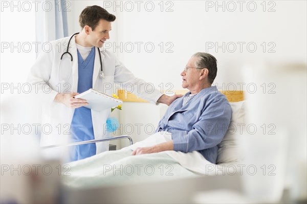 Caucasian doctor talking to Senior patient in hospital