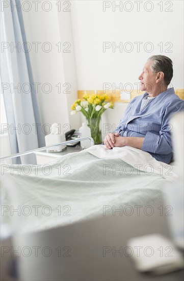 Senior Caucasian man sitting in hospital bed