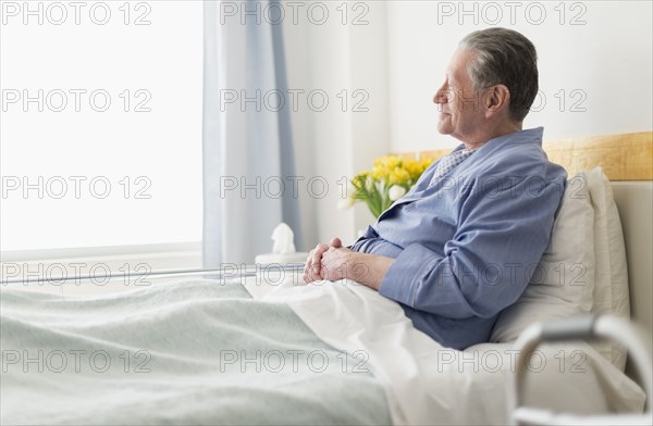 Senior Caucasian man sitting in hospital bed