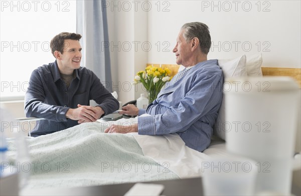 Caucasian son visiting father in hospital