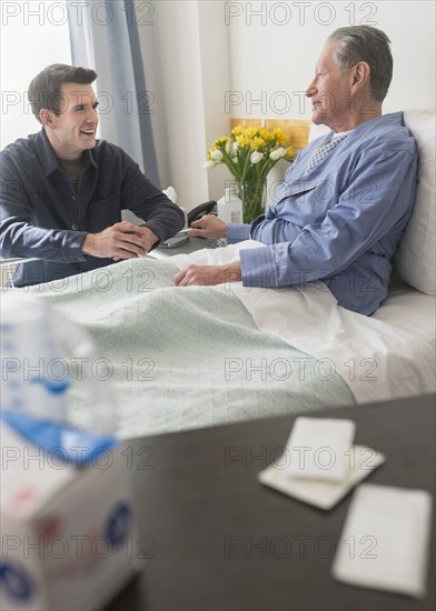 Caucasian son visiting father in hospital