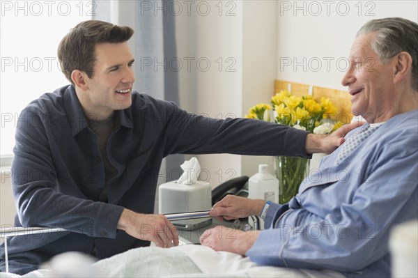 Caucasian son visiting father in hospital