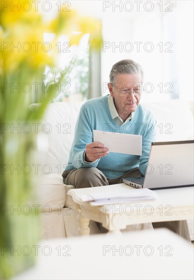 Senior Caucasian man paying bills online