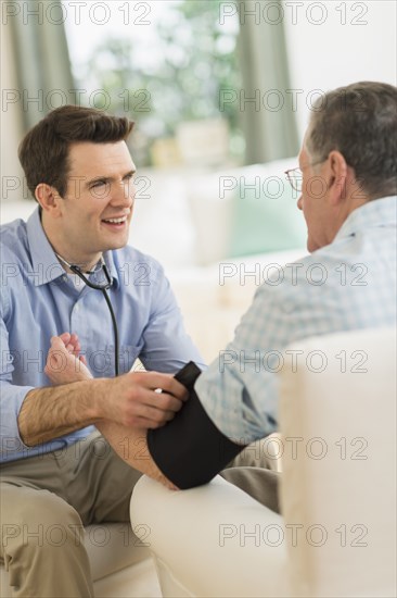 Caucasian doctor taking patient's blood pressure at home