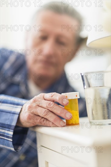 Senior Caucasian man taking medication