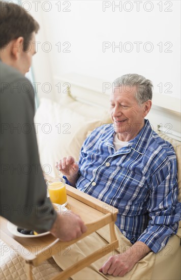 Senior Caucasian man having breakfast in bed