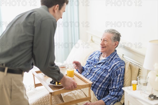 Senior Caucasian man having breakfast in bed