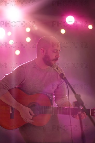 Hispanic musician playing guitar on stage