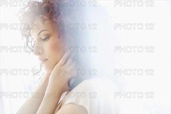 Hispanic woman holding chin in hands