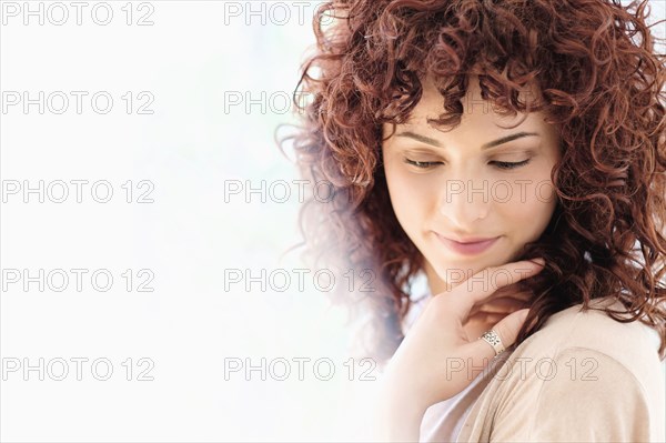 Hispanic woman holding chin in hands