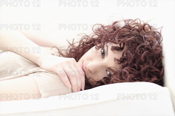 Hispanic woman laying on sofa