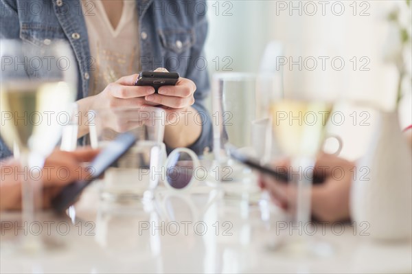 People using cell phones at dinner table