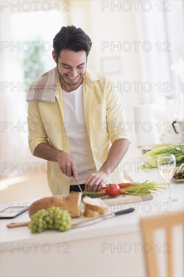 Mixed race man cooking in kitchen