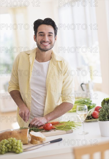 Mixed race man cooking in kitchen